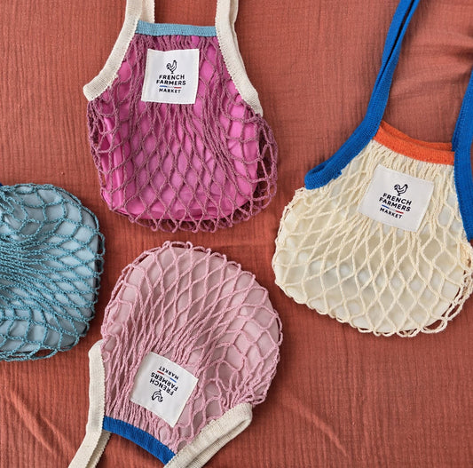 Set of colorful mesh bags with visible branding on a red background