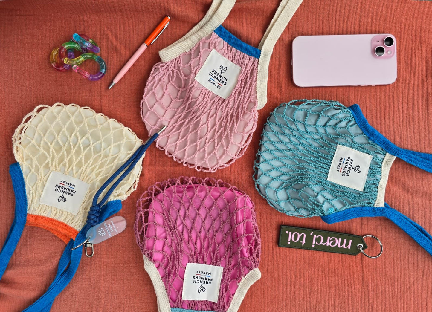 Set of colorful mesh bags with tags on a red background
