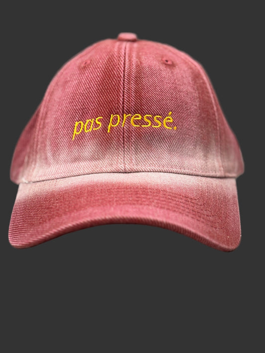 Red cap with yellow text 'pas presé' on a gray background