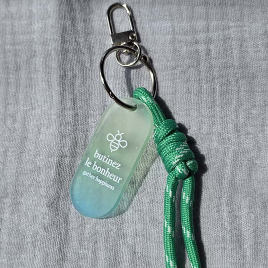 Green keychain with a tag on a gray background