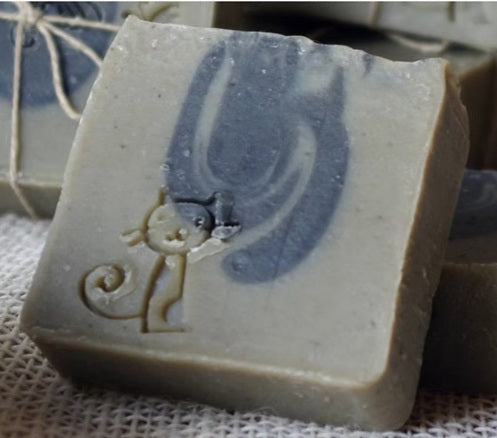 Bar of soap with a cat design on a textured surface