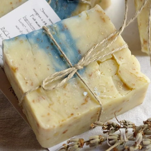 Handmade soap bars with natural texture, tied with twine on a soft background.